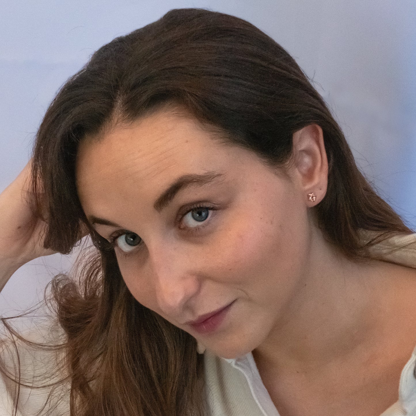 Mujer de cabello castaño usando pendientes de estrella rose gold