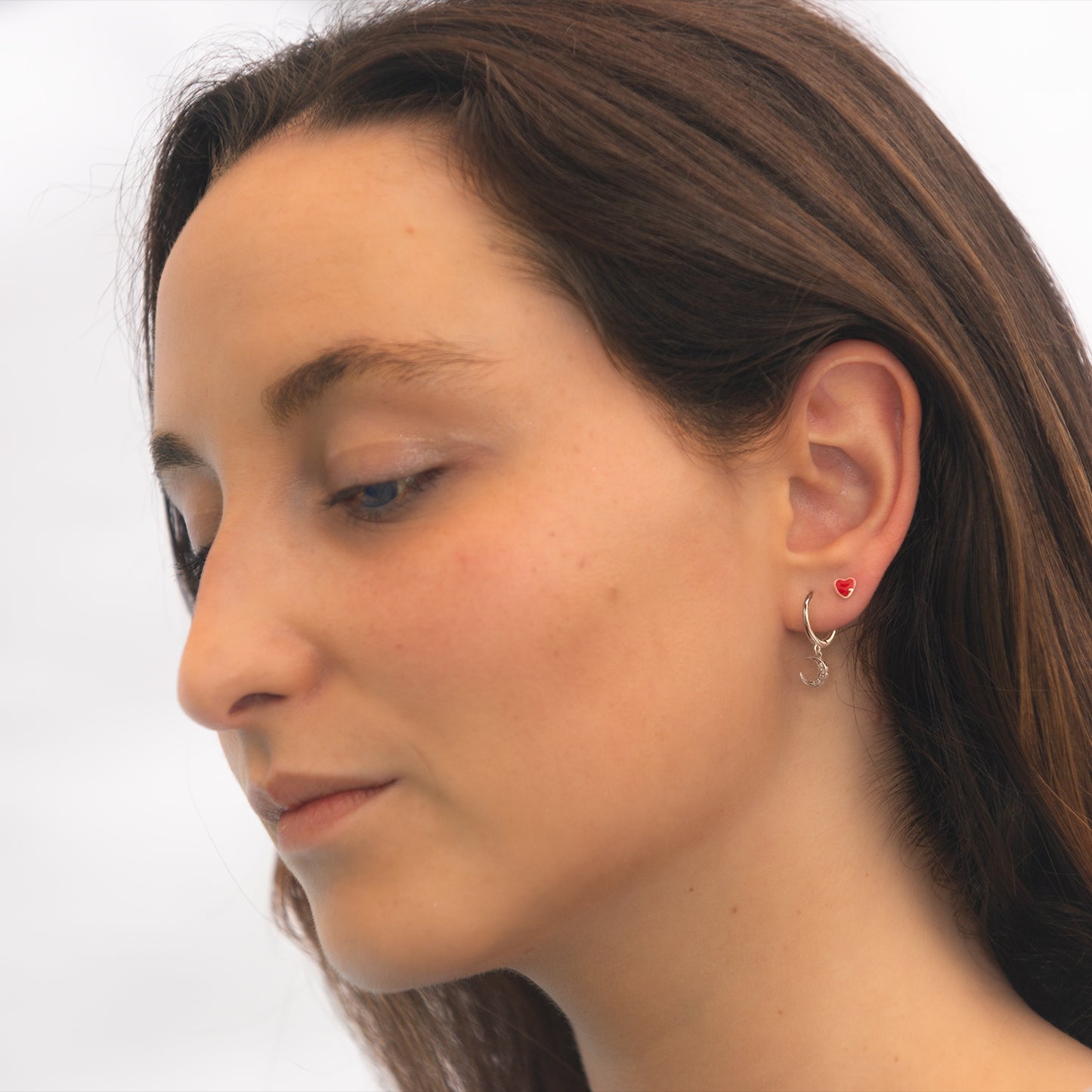 Mujer con aros de corazón rojo como segundo aro.
