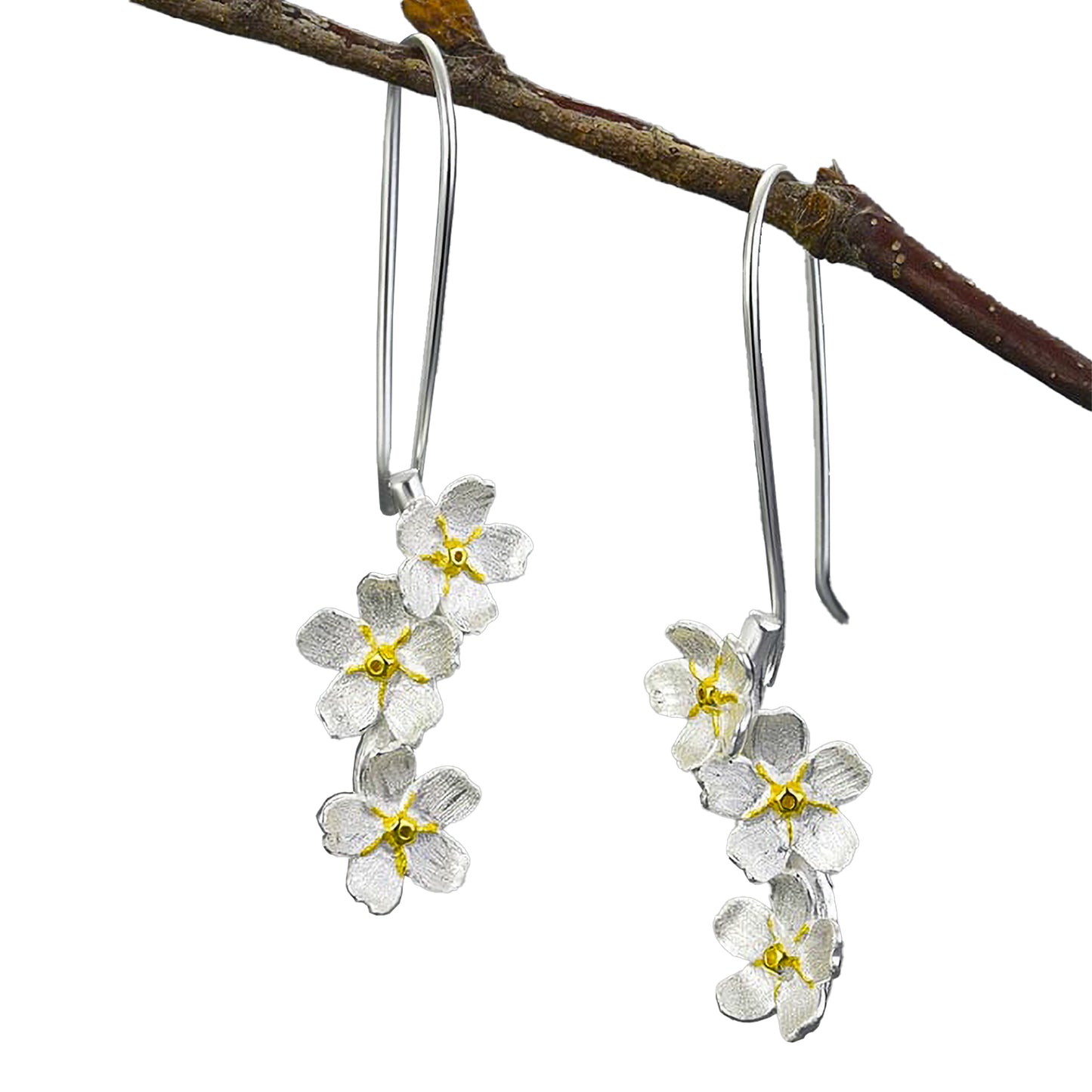 Aros de flores plateadas y centros dorados, colgando de una rama.