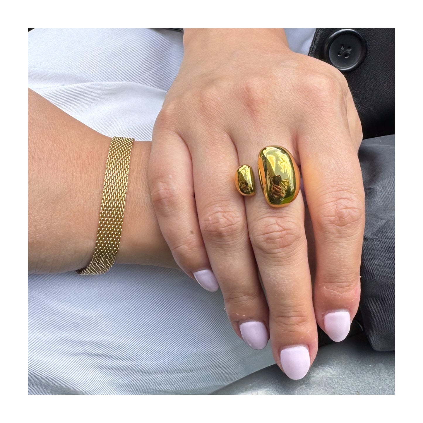 Modelo luciendo anillo dorado abierto con doble óvalo
