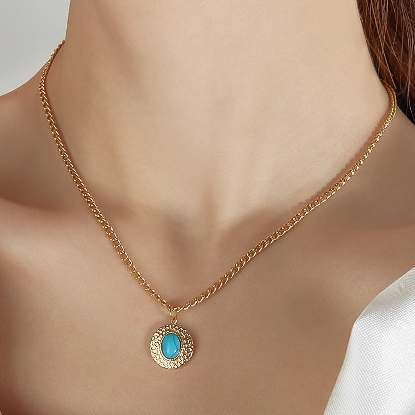 Modelo con collar con boho con disco dorado y piedra turquesa.