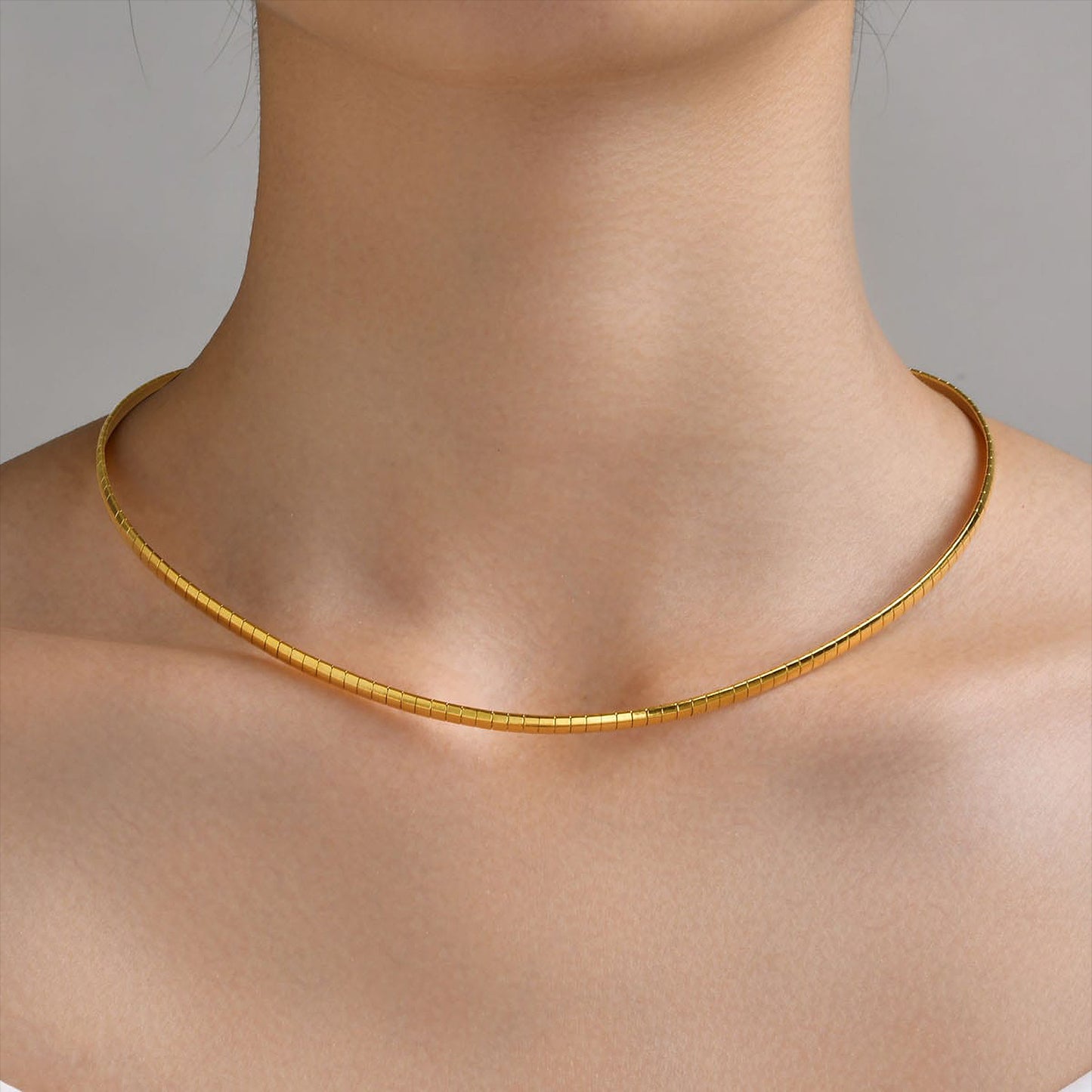 Modelo con choker rígido dorado