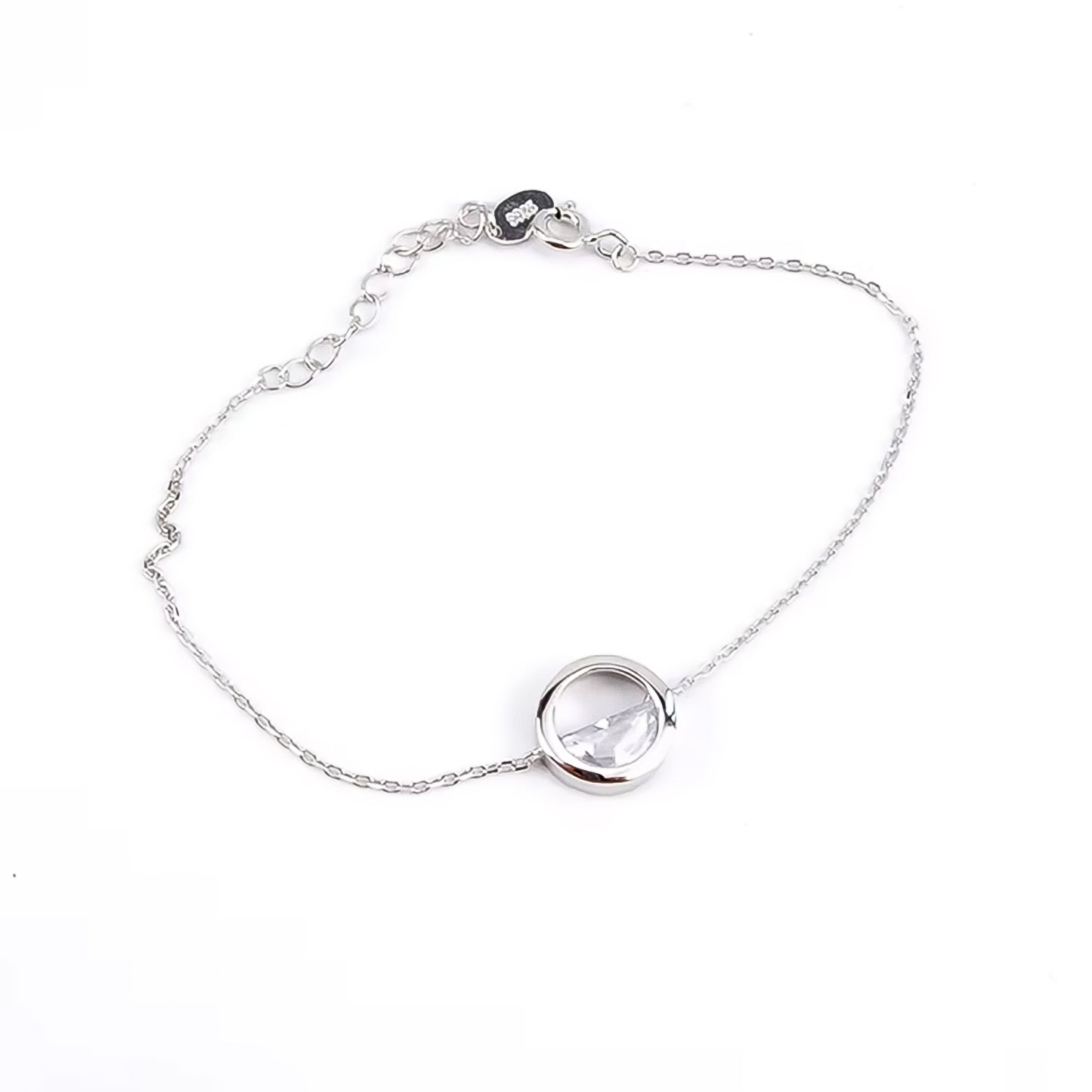 Pulsera de plata con un abalorio de marco circular y un cristal transparente en su interior sobre fondo blanco