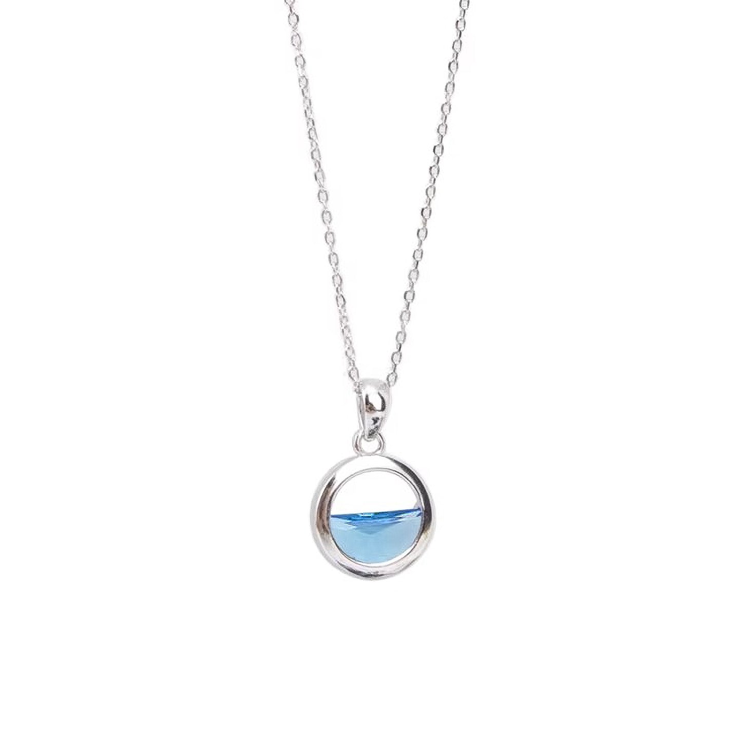 Collar de plata con colgante de cristal azul sobre fondo blanco